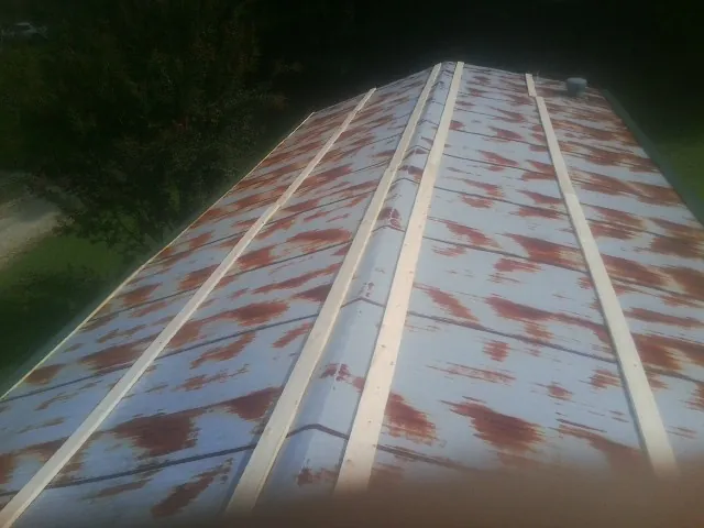 Rusted metal roof panels with new wood purlins before replacement — Storm Damage Roof Repair in Harrison by Roofing Brothers